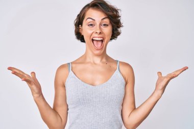 Gündelik kıyafetler giyen genç İspanyol kadın zaferi mutlu bir gülümsemeyle ve kazanan ifadeyle kutluyor. 