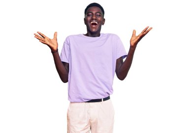 Genç afro-amerikan adam gündelik giysiler giyip çılgınlığı kutluyor ve başarıya hayret ediyor kolları açık ve gözleri açık heyecanla bağırıyor. Kazanan konsept 