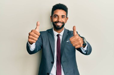 Yakışıklı, İspanyol takım elbiseli, kravatlı, komik hareketler yapan, parmaklarını boynuzlarının üzerinde gezdiren bir adam. 