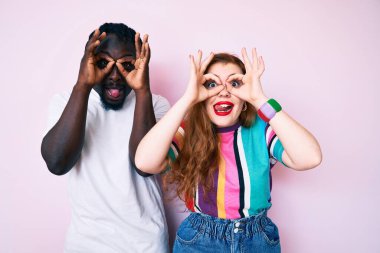 Irklar arası çiftler günlük kıyafetler giyip normal hareketler yapıyorlar. Dürbün gibi dillerini çıkarıyorlar, gözler parmaklarından bakıyor. çılgın ifade. 