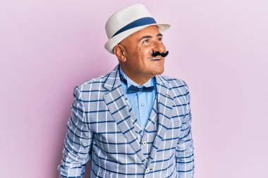 Olgun, orta doğulu bıyıklı, klasik ve şık moda tarzlı bir adam. Tarafını arıyor, rahat profil pozu veriyor, doğal bir yüzü ve kendine güvenen bir gülümsemesi var.. 