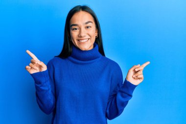 Kış süveteri giyen genç Asyalı kadın farklı yönleri gösteren kendine güvenle gülümsüyor. reklam için kopyalama alanı 