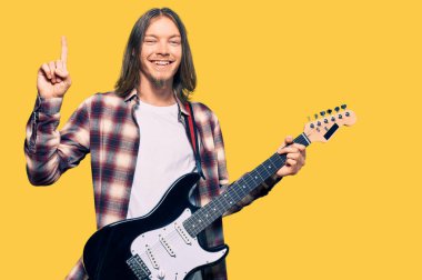Uzun saçlı, elektro gitar çalan yakışıklı beyaz adam bir fikre ya da soru işaretine şaşırdı ve mutlu bir yüzle işaret etti. 