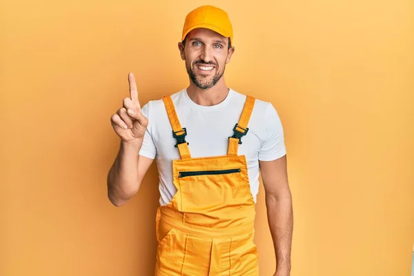 Ung Stilig Man Bär Handyman Uniform Över Gul Bakgrund Pekar — Stockfoto