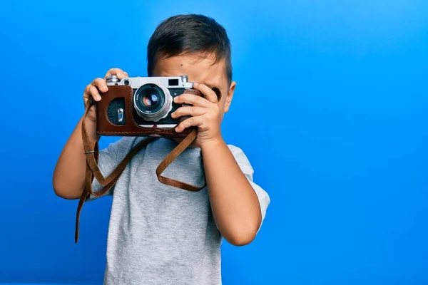 愛らしいラテン写真家幼児笑顔幸せな使用ヴィンテージカメラ上の隔離された青の背景 — ストック写真