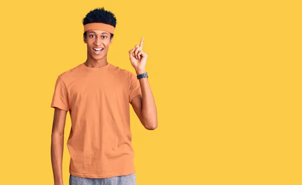 スポーツウェアを着た若いアフリカ系アメリカ人男性が成功したアイデアで指を指しています 興奮して幸せよ 第1位 — ストック写真