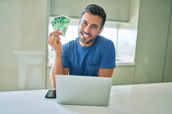 Joven Hombre Guapo Sonriendo Feliz Sosteniendo Billetes Israelíes Shekels Casa —  Fotos de Stock