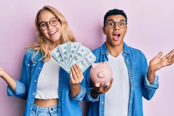 Joven Pareja Interracial Sosteniendo Dólares Alcancía Celebrando Logro Con Sonrisa — Foto de Stock