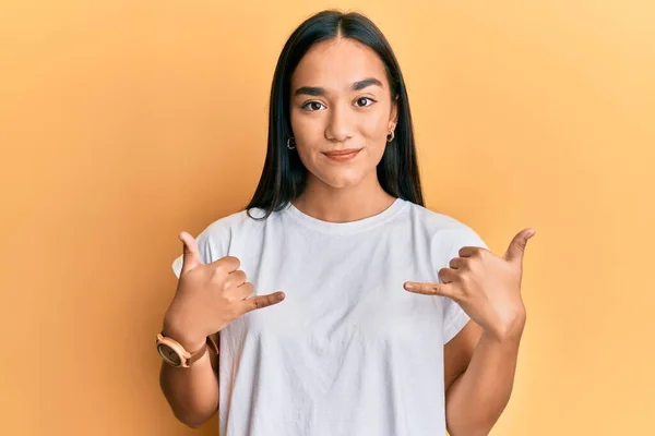 Молодая Азиатка Делает Знак Шака Расслабленными Руками Серьезным Выражением Лица — стоковое фото