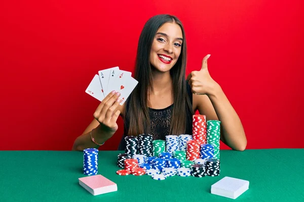 Jovem Hispânica Sentada Mesa Jogando Poker Segurando Cartas Sorrindo Feliz — Fotografia de Stock