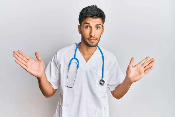 Jovem Homem Bonito Vestindo Uniforme Médico Estetoscópio Sem Noção Confundido — Fotografia de Stock