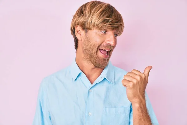 Young Blond Man Wearing Casual Clothes Pointing Thumb Side Smiling — Stock Photo, Image