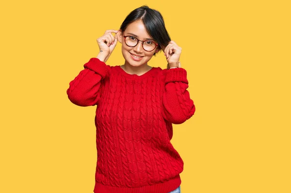 短い髪のカジュアルなセーターや眼鏡を身に着けている若い美しいヒスパニック系の女性は指で耳を引く笑みを浮かべて 面白いジェスチャー オーディション問題 — ストック写真