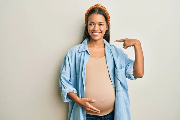 Beautiful Hispanic Woman Expecting Baby Touching Pregnant Belly Looking Confident — Stock Photo, Image