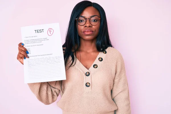 Young african american woman showing a failed exam thinking attitude and sober expression looking self confident
