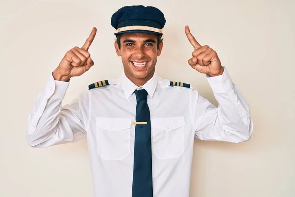 Joven Hombre Hispano Vistiendo Uniforme Piloto Avión Sonriendo Asombrado Sorprendido —  Fotos de Stock