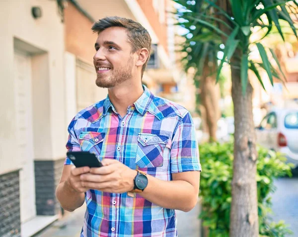 Joven Hombre Caucásico Sonriendo Feliz Usando Teléfono Inteligente Ciudad —  Fotos de Stock