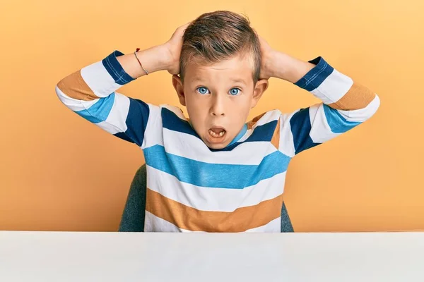 Adorable Niño Caucásico Con Ropa Casual Sentado Mesa Loco Asustado — Foto de Stock