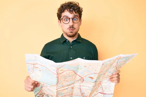 Homem Caucasiano Jovem Com Cabelo Encaracolado Segurando Mapa Cidade Bochechas — Fotografia de Stock
