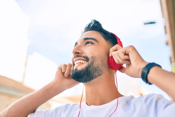 Jovem Árabe Homem Sorrindo Feliz Usando Fones Ouvido Andando Cidade — Fotografia de Stock