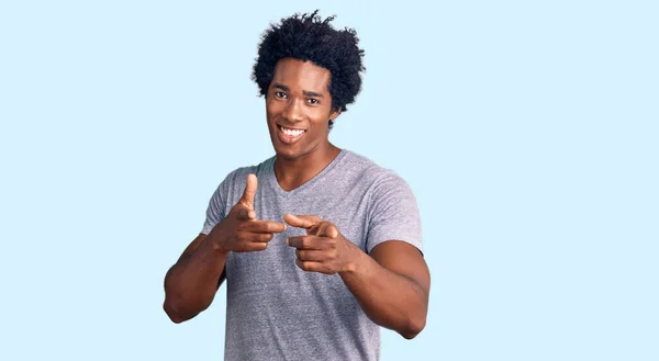 アフロの髪をしたハンサムなアフリカ系アメリカ人の男性は 幸せと面白い顔でカメラに指を指してカジュアルな服を着ています 良いエネルギーと振動は — ストック写真