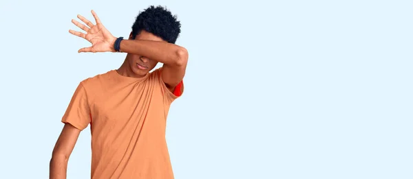 若いアフリカ系アメリカ人の男性は 腕で目を覆うカジュアルな服を着て 真剣に悲しい顔をしています 目立たず隠し拒否の概念 — ストック写真