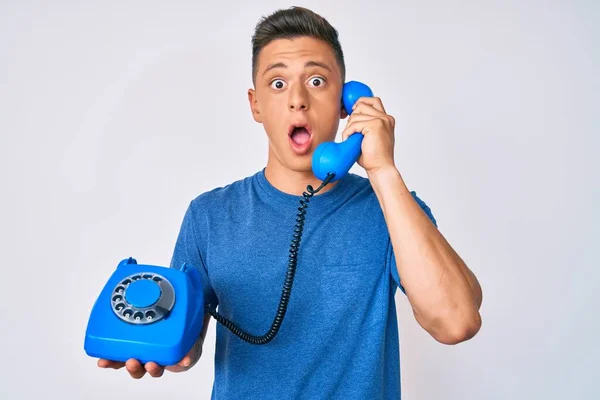 Young Hispanic Boy Holding Vintage Telephone Afraid Shocked Surprise Amazed — Stock fotografie