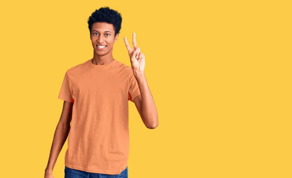 年轻的非洲裔美国人穿着休闲装 微笑着看着摄像机 手指头在做胜利的标志 第二点 — 图库照片