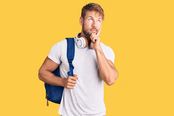 Νεαρός Καυκάσιος Που Φοράει Φοιτητικό Σακίδιο Και Ακουστικά Σοβαρό Πρόσωπο — Φωτογραφία Αρχείου