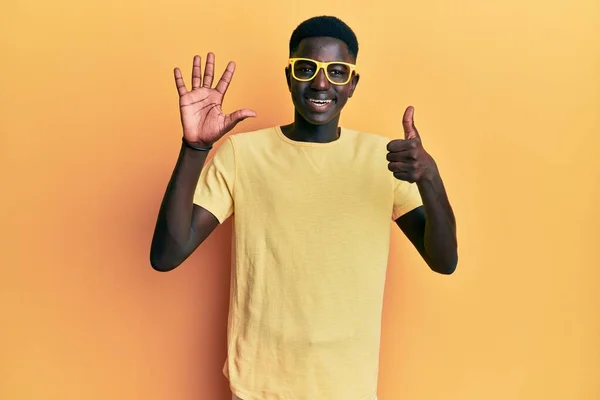 年轻的非洲裔美国人 身穿休闲装 戴着眼镜 头戴六号手指 面带微笑 自信而快乐 — 图库照片