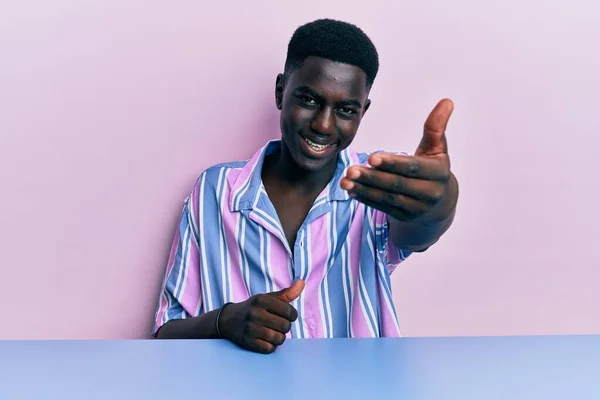 Joven Hombre Afroamericano Vistiendo Ropa Casual Sentado Mesa Sonriendo Amistoso — Foto de Stock