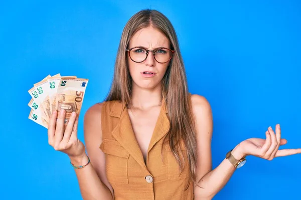 Menina Loira Jovem Segurando Notas Euro Sem Noção Expressão Confusa — Fotografia de Stock