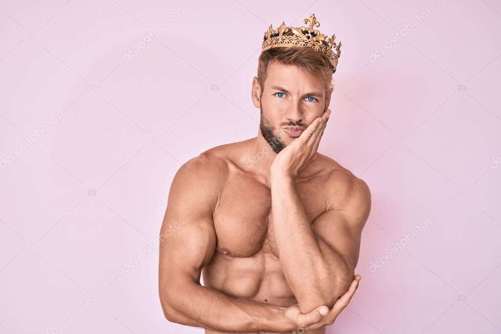 Young caucasian man shirtless wearing king crown thinking looking tired and bored with depression problems with crossed arms. 