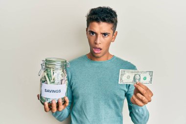 Genç, yakışıklı, Afro-Amerikan bir adam elinde kavanozla şok olmuş, şüpheci ve alaycı bakıyor, ağzı açık kalmış. 