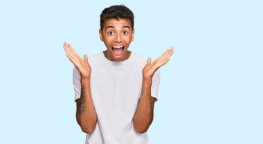 Genç, yakışıklı, beyaz tişört giyen Afro-Amerikan bir adam çılgın ve başarıyı kollarını kaldırıp heyecanla haykırarak kutluyor. Kazanan konsept 