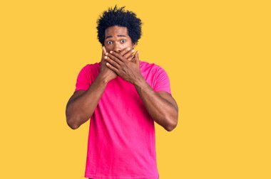 Afro saçlı, sıradan pembe tişörtlü yakışıklı Afro-Amerikan adam yanlışlıkla ağızlarını kapatarak şok geçirdi. gizli kavram. 
