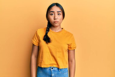 Gündelik giysiler giyen genç Latin kadın üzgün ve endişeli, kızgın ve korkmuş bir şekilde ağlıyor. hüzünlü ifade. 