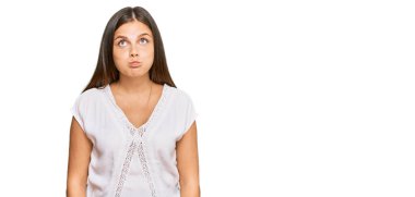 Gündelik kıyafetler giyen, komik yüzlü, yanak şişiren beyaz bir kadın. Havayla şişmiş ağız, çılgın bir ifade.. 