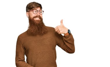 Genç İrlandalı kızıl elbiseli ve gözlüklü adam gururlu görünüyor, gülümsüyor. 