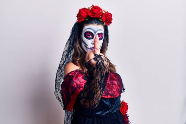 Young woman wearing day of the dead costume over white showing middle finger, impolite and rude fuck off expression 