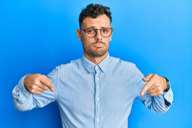 Sakallı, sıradan kıyafetler giyen ve gözlüklü, yorgun, yarı yüz, göz ve ağız kaplamalı yakışıklı bir adam. Yüzüm acıyor.. 