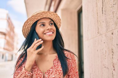 Genç Afro-Amerikan turist kadın tatilde. Şehirdeki akıllı telefondan konuşuyor..