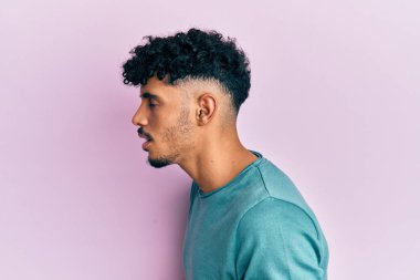 Genç Arap yakışıklı adam, elleri karnında gündelik giysiler giyiyor çünkü mide bulantısı, acı verici bir hastalık kendini iyi hissetmiyor. Ağrı kavramı. 