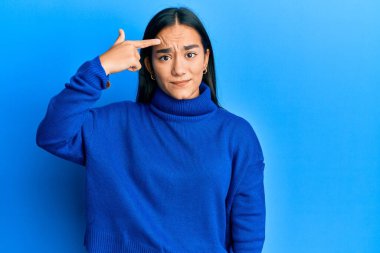 Sıradan bir kazak giyen genç Asyalı kadın alnındaki sivilceden mutsuz, siyah noktalı çirkin bir enfeksiyon gösteriyor. sivilce ve deri problemi 