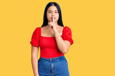 Genç ve güzel Asyalı bir kız günlük kıyafetler giyip sessiz olmak istiyor. sessizlik ve gizli konsept. 