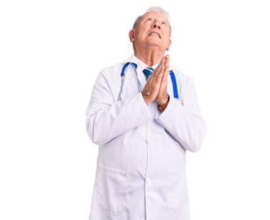 Doktor önlüğü ve steteskop giyen yaşlı, beyaz saçlı yakışıklı adam yüzünde umut ifadesi olan ve endişeli bir ifadeyle yalvarıyor ve dua ediyor. Yalvarıyor. 