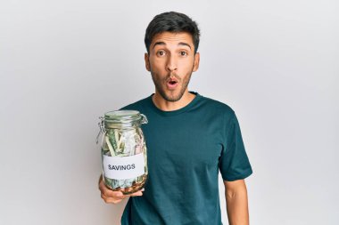 Elinde birikimleri olan genç ve yakışıklı bir adam sürpriz yapmak için ağzı açık, korkmuş ve hayrete düşmüş, inançsız bir yüz. 