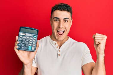 Yakışıklı genç adam hesap makinesi gösteriyor. Gururla bağırıyor, zaferi kutluyor ve kollarını kaldırarak çok heyecanlı. 