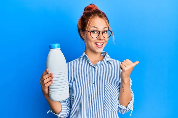 Молода Руда Жінка Тримає Літрову Пляшку Молока Вказуючи Великий Палець — стокове фото