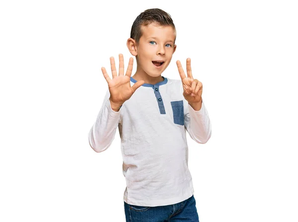 自信を持って幸せな笑顔ながら カジュアルな服を着て 指の番号7で指差す愛らしい白人の子供 — ストック写真